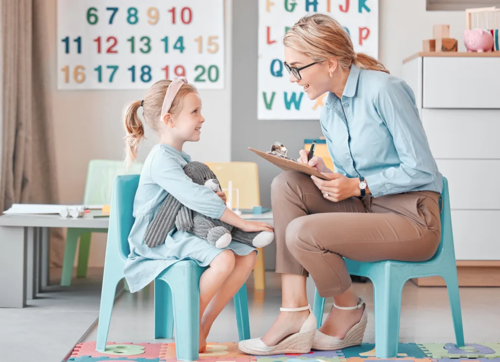 Girl child, psychologist and writing with talk, smile and listening for support, help and school counselling program. Woman, female kid and conversation for mental health, psychology and wellness